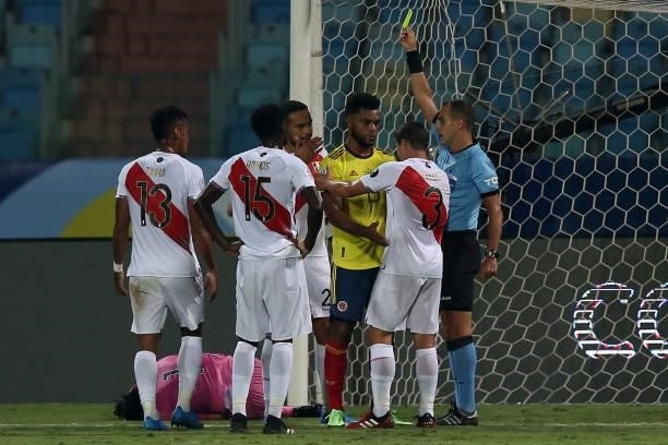 Referee Esteban Ostojich shows a yellow card to Miguel Borja of Colombia after a foul against Pedro Gallese goalkeeper of Peru during a group b match...