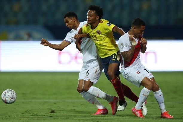 Juan Cuadrado of Colombia competes for the ball with Miguel Trauco and Yoshimar Yotún of Peru during a group b match between Colombia and Peru as...