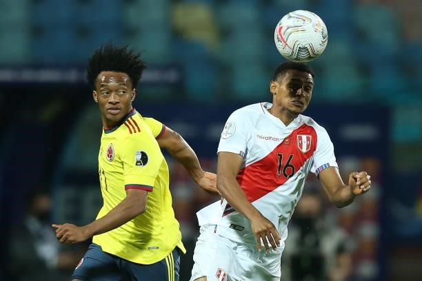 Juan Cuadrado of Colombia jumps for the ball with Marcos López of Peru during a group B match between Colombia and Peru as part of Copa America...