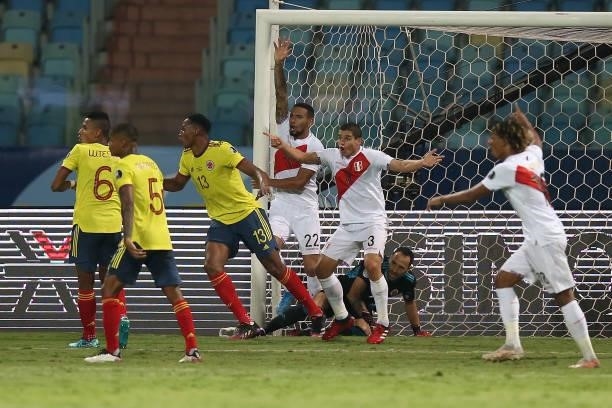 Alexander Callens and Aldo Corzo of Peru celebrate with teammates after their second goal scored by an own goal of Yerry Mina of Colombia during a...