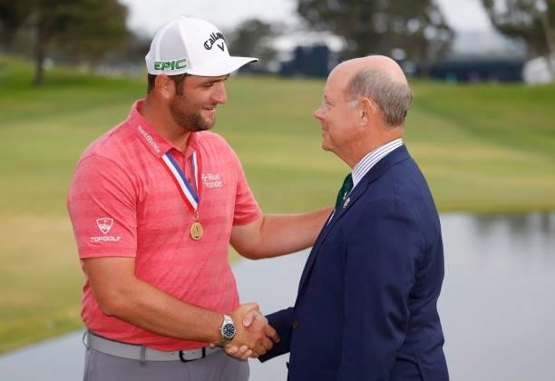 Jon Rahm of Spain is congratulated by Mike Davis, CEO of the USGA, after winning during the final round of the 2021 U.S. Open at Torrey Pines Golf...
