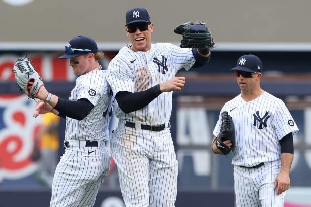 Clint Frazier and Aaron Judge of the New York Yankees celebrate as Brett Gardner looks on after defeating the Oakland Athletics 7-5 during a game at...