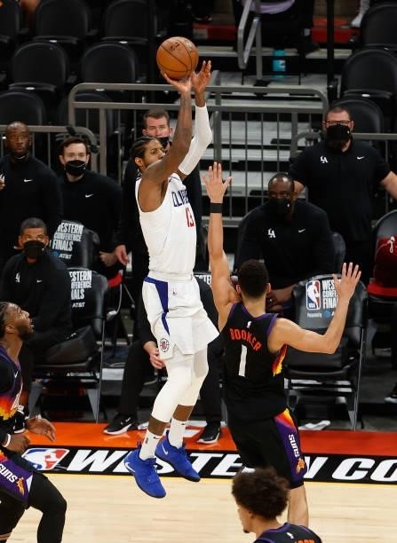 Paul George of the LA Clippers attempts a shot over Devin Booker of the Phoenix Suns during the second half of game one of the Western Conference...