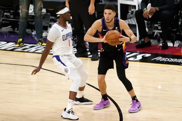 Devin Booker of the Phoenix Suns looks to pass against Reggie Jackson of the LA Clippers during the second half of game one of the Western Conference...