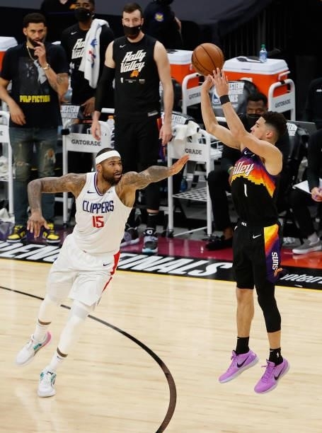 Devin Booker of the Phoenix Suns attempts a three-point shot over DeMarcus Cousins of the LA Clippers during the second half of game one of the...
