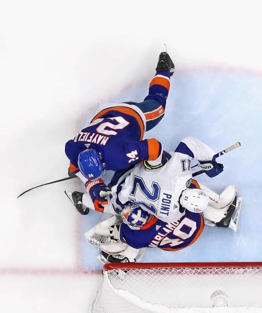 Scott Mayfield of the New York Islanders checks Brayden Point of the Tampa Bay Lightning into Semyon Varlamov in Game Four of the Stanley Cup...