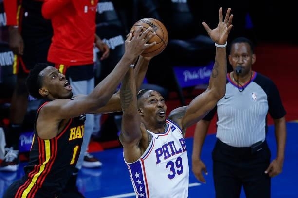 Onyeka Okongwu of the Atlanta Hawks and Dwight Howard of the Philadelphia 76ers reach for a rebound during the second quarter during Game Seven of...