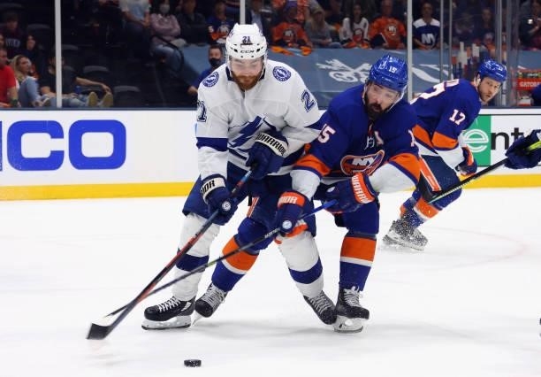 Brayden Point of the Tampa Bay Lightning is checked by Cal Clutterbuck of the New York Islanders in Game Four of the Stanley Cup Semifinals during...