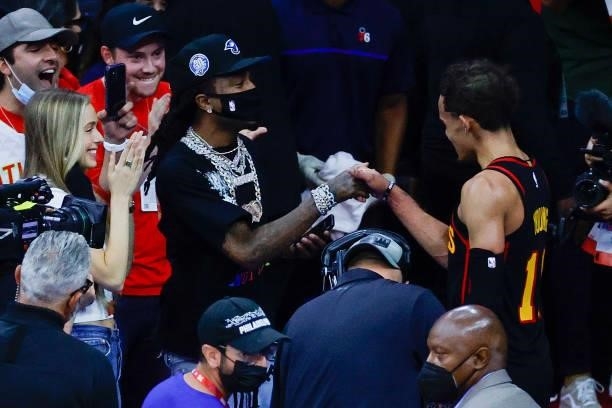 Quavo and Trae Young of the Atlanta Hawks shake hands after the Atlanta Hawks defeat the Philadelphia 76ers during Game Seven of the Eastern...