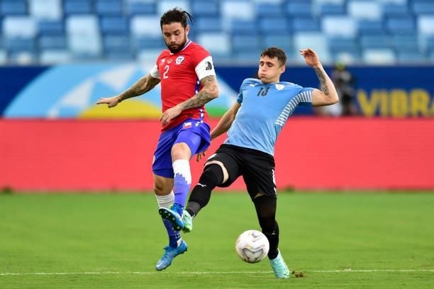 Eugenio Mena of Chile competes for the ball with Giovanni Gonzalez of Uruguay during a group A match between Uruguay and Chile as part of Conmebol...