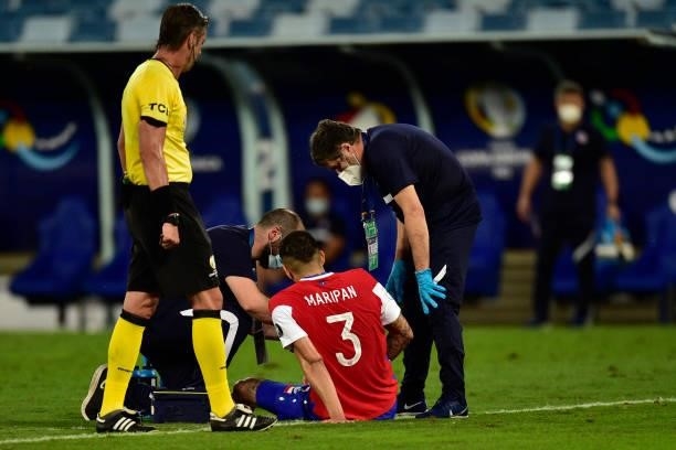 Guillermo Maripán of Chile receives medical attention after being injured during a group A match between Uruguay and Chile as part of Conmebol Copa...
