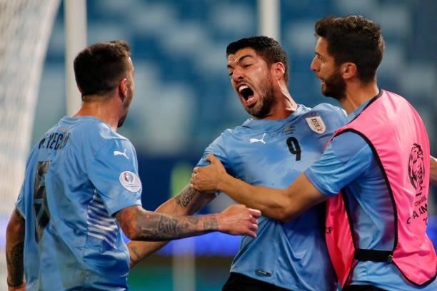 Luis Suarez of Uruguay celebrates with teammates after his team first goal scored by an own goal of Arturo Vidal of Chile during a group A match...