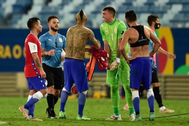 Arturo Vidal of Chile greets Nahitan Nandez and Fernando Muslera goalkeeper of Uruguay during a group A match between Uruguay and Chile as part of...