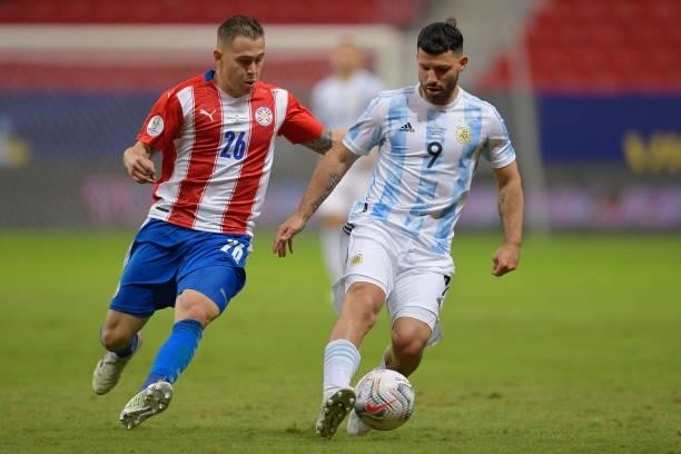 Robert Piris da Motta of Paraguay competes for the ball with Sergio Agüero of Argentina during a group A match between Argentina and Paraguay as part...