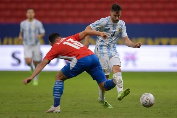 Alberto Espinola of Paraguay competes for the ball with Nicolas Tagliafico of Argentina during a group A match between Argentina and Paraguay as part...