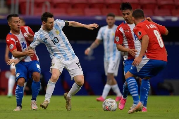 Lionel Messi of Argentina competes for the ball with Ángel Cardozo , Santiago Arzamendia and Richard Sanchez of Paraguay during a group A match...