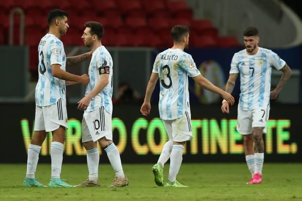 Lionel Messi of Argentina celebrates with teammates Cristian Romero, Nicolas Tagliafico and Rodrigo De Paul after winning a group A match between...