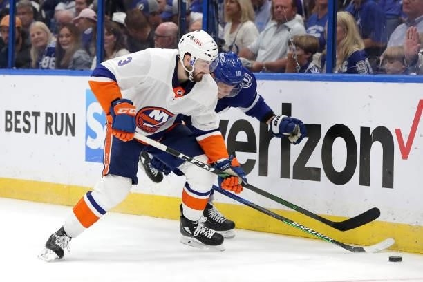 Adam Pelech of the New York Islanders and Ondrej Palat of the Tampa Bay Lightning battle for the puck during the third period in Game Five of the...