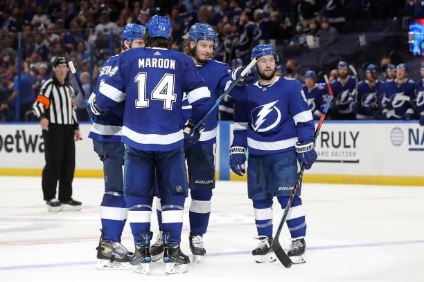 Luke Schenn of the Tampa Bay Lightning is congratulated by his teammates after scoring a goal against the New York Islanders during the third period...