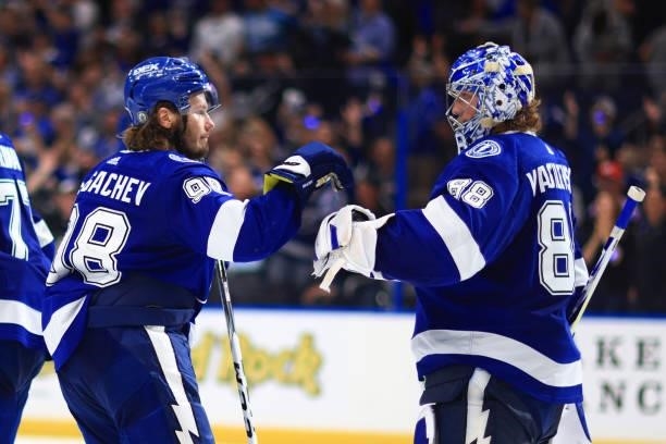 Andrei Vasilevskiy of the Tampa Bay Lightning is congratulated by Mikhail Sergachev after the team's 8-0 victory against the New York Islanders in...
