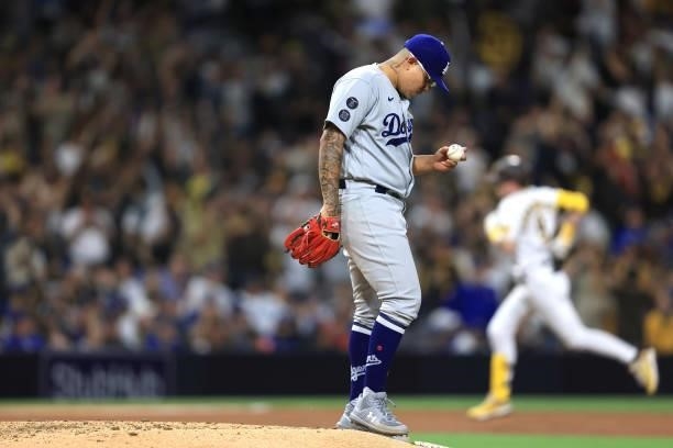 Julio Urias of the Los Angeles Dodgers looks on as Jake Cronenworth of the San Diego Padres rounds the bases after hitting a two-run homerun during...