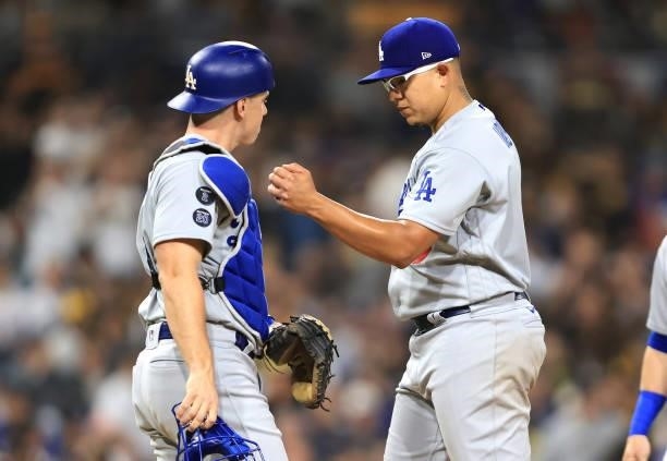 Will Smith talks with Julio Urias of the Los Angeles Dodgers after he allowed a two-run homerun to Jake Cronenworth of the San Diego Padres during...
