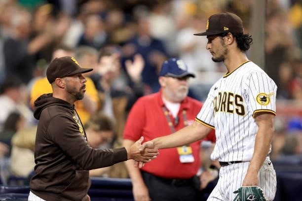 Manager Jayce Tingler congratulates Yu Darvish of the San Diego Padres as he walks to the dugout after recording his career 1500th strikeout during...