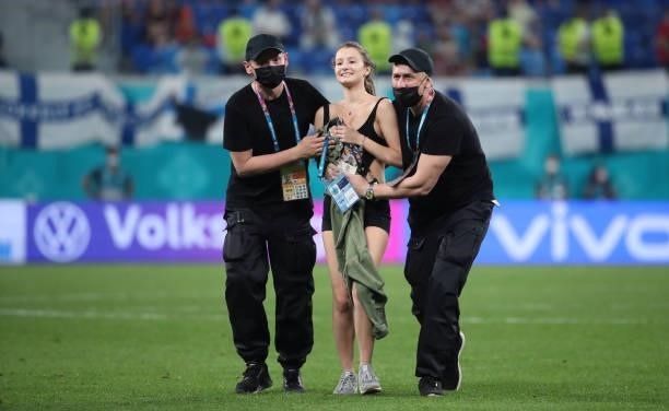 Supporter is escorted by two chaperones during the UEFA Euro 2020 Championship Group B match between Finland and Belgium at Saint Petersburg Stadium...