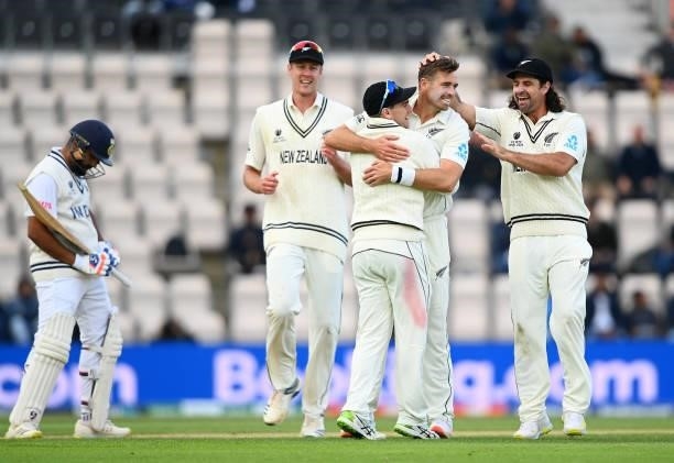 Tim Southee of New Zealand celebrates taking the wicket of Rohit Sharma of India with Tom Latham and Coling De Grandhomme during Day 5 of the ICC...