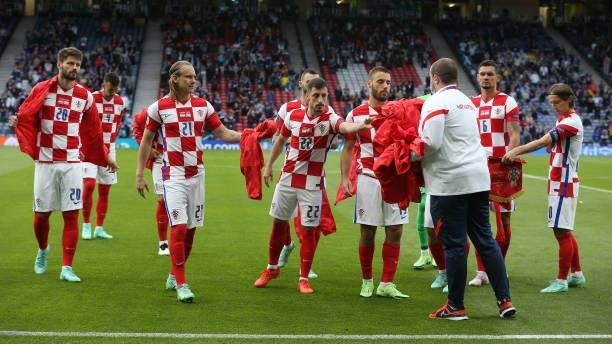 The Croatia players give their tracksuit tops to a kit man during the UEFA Euro 2020 Championship Group D match between Croatia and Scotland at...
