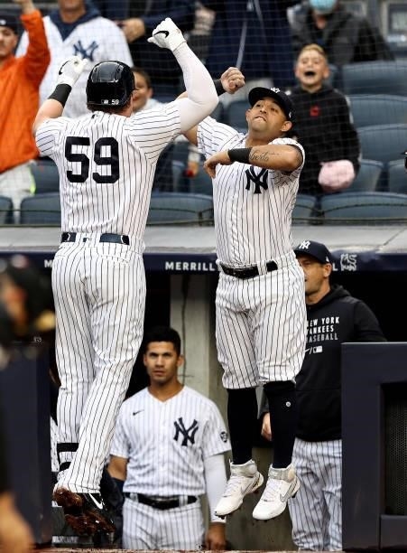 Luke Voit of the New York Yankees is congratulated by teammate Rougned Odor after Voit hit a solo home run in the first inning against the Kansas...