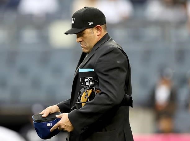 Home plate umpire Brian Knight inspects Kansas City Royals starting pitcher Brady Singer's hat in the first inning against the New York Yankees at...