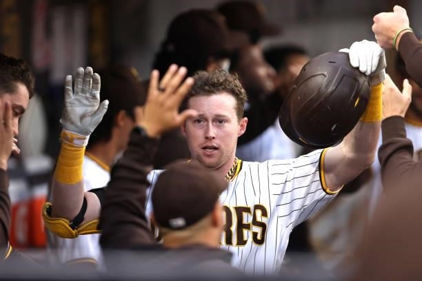 Jake Cronenworth of the San Diego Padres is congratulated by teammates in the dugout after hitting a two-run homerun during the first inning of a...