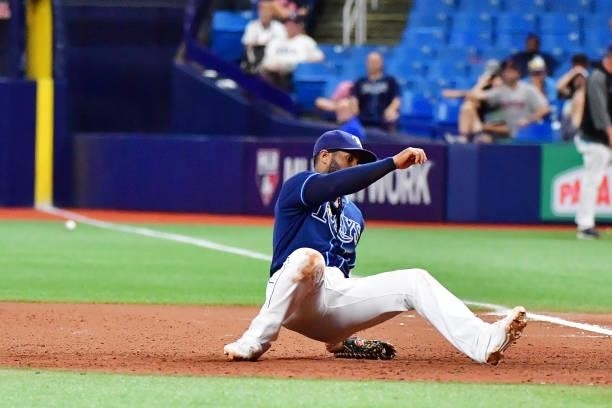 Yandy Diaz of the Tampa Bay Rays falls back after Rafael Devers of the Boston Red Sox hit a two-run single in the 11th inning at Tropicana Field on...