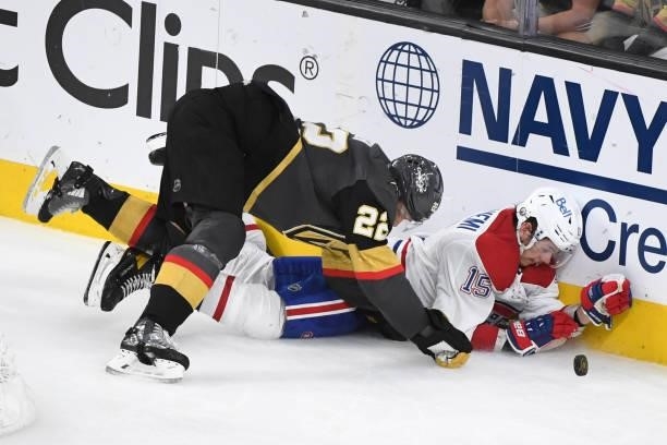 Nick Holden of the Vegas Golden Knights and Jesperi Kotkaniemi of the Montreal Canadiens crash into the boards during the third period in Game Five...