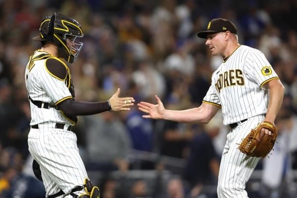 Victor Caratini and Mark Melancon of the San Diego Padres celebrate defeating the Los Angeles Dodgers 3-2 in a game at PETCO Park on June 22, 2021 in...