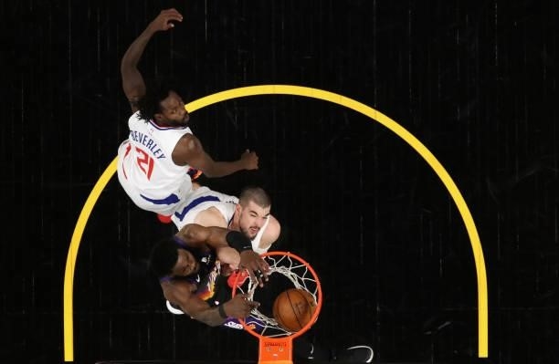 Deandre Ayton of the Phoenix Suns slam dunks the ball over Ivica Zubac and Patrick Beverley of the LA Clippers during the second half of game two of...