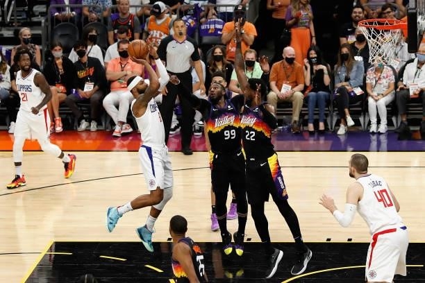 Marcus Morris Sr. #8 of the LA Clippers attempts a shot over Jae Crowder and Deandre Ayton of the Phoenix Suns during the first half of game two of...