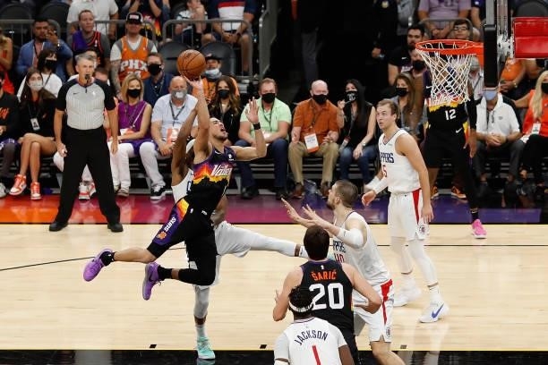 Devin Booker of the Phoenix Suns attempts a shot over Ivica Zubac of the LA Clippers during the second half of game two of the Western Conference...