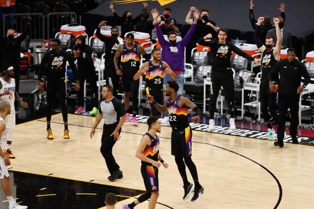 Deandre Ayton of the Phoenix Suns reacts alongside Devin Booker, Mikal Bridges and Torrey Craig after a slam dunk against the LA Clippers during the...