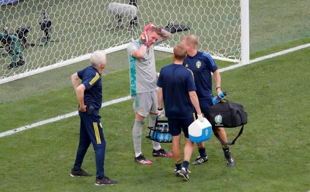 Robin Olsen of Sweden reacts as he receives medical treatment during the UEFA Euro 2020 Championship Group E match between Sweden and Poland at Saint...