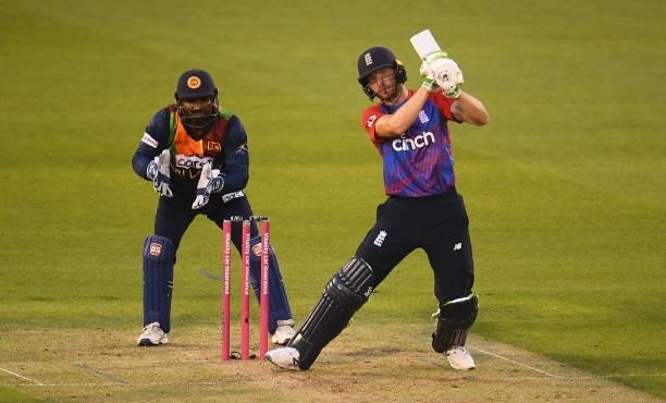 Jos Buttler of England plays a shot as Kusal Perera of Sri Lanka looks on during the T20 International Series First T20I match between England and...