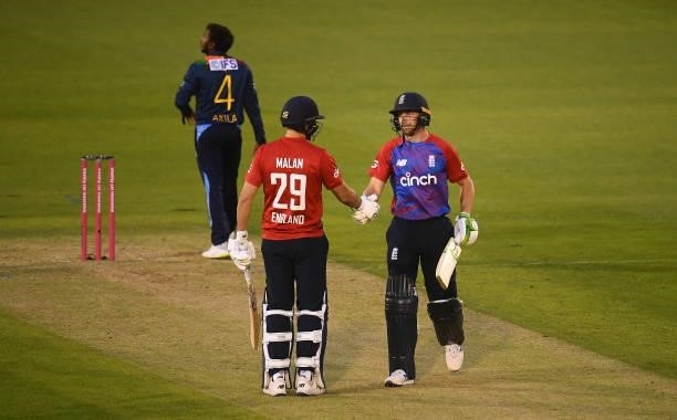 Jos Buttler of England celebrates after reaching their half century with team mate Dawid Malan during the T20 International Series First T20I match...