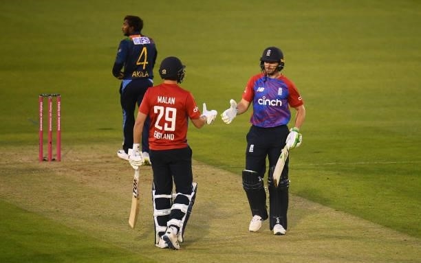 Jos Buttler of England celebrates after reaching their half century with team mate Dawid Malan during the T20 International Series First T20I match...