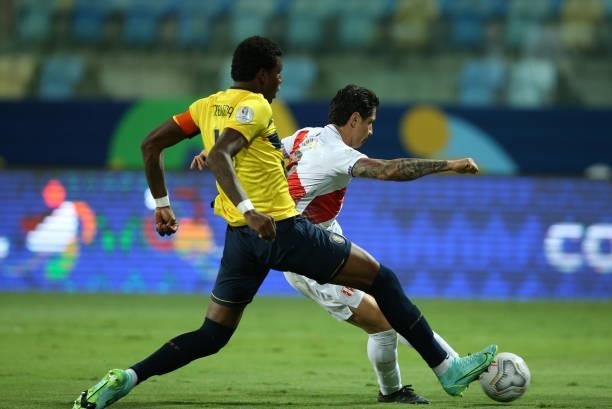 Gianluca Lapadula of Peru kicks the ball against Robert Arboleda of Ecuador to score the the first goal of his team during a Group B match between...