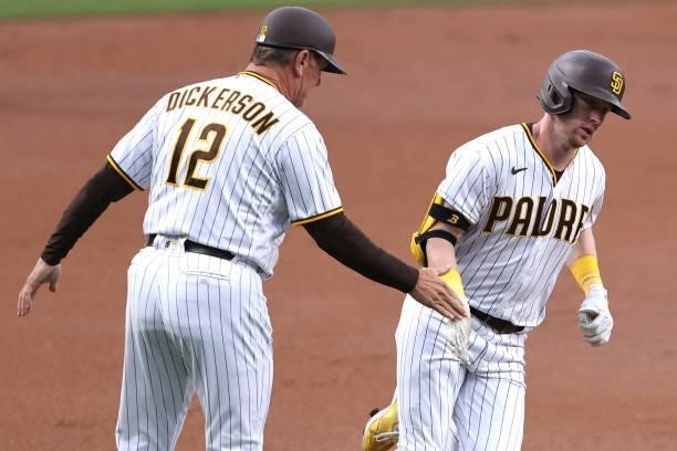Third base coach Bobby Dickerson congratulates Jake Cronenworth of the San Diego Padres as he rounds third base after hitting a solo homerun during...