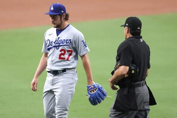 Umpire James Hoye walks toward Trevor Bauer of the Los Angeles Dodgers to check for foreign substances during the first inning of a game against the...