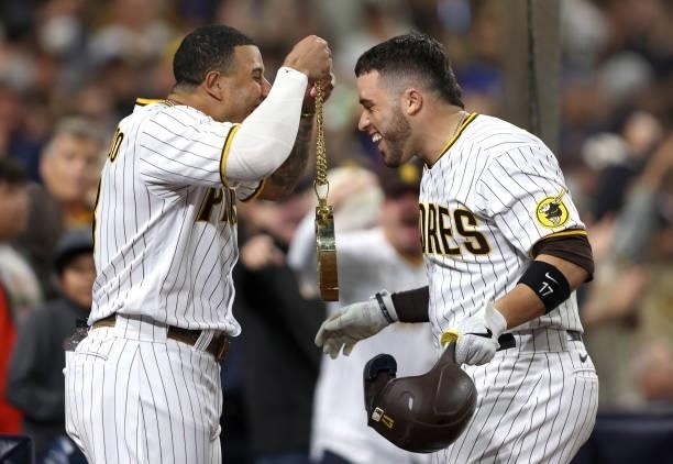 Manny Machado congratulates Victor Caratini of the San Diego Padres after his solo homerun during the seventh inning of a game against the Los...