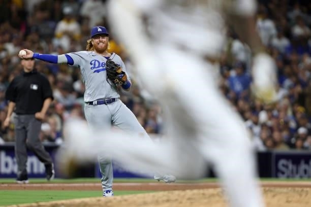 Justin Turner of the Los Angeles Dodgers is unable to throw out Manny Machado of the San Diego Padres as he reaches on a single during the eighth...