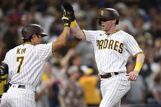 Ha-Seong Kim congratulates Jake Cronenworth after he scores when Trent Grisham of the San Diego Padres walked during the eighth inning of a game...